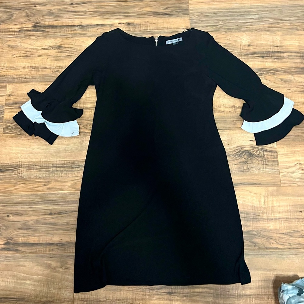 A black, knee length, quarter length ruffled sleeve dress
